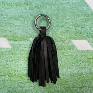A black leather tassel keychain on top of a football field.