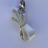 A white bow tie with gold ribbon hanging from it.