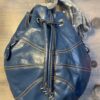 A blue purse sitting on top of a wooden table.