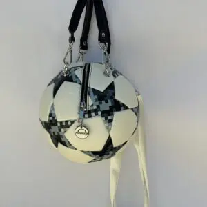 A white and black soccer ball bag hanging on the wall.
