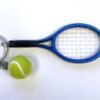A tennis racket and ball are on the table.