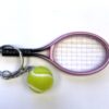 A tennis racket and ball are on the table.